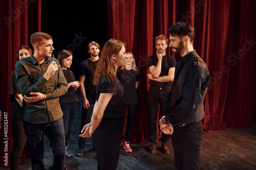 Eye contact practice. Group of actors in dark colored clothes on rehearsal in the theater