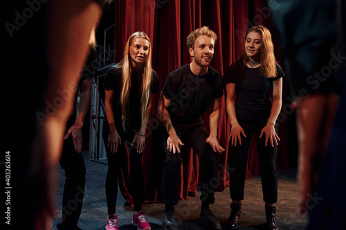 Practice in progress. Group of actors in dark colored clothes on rehearsal in the theater