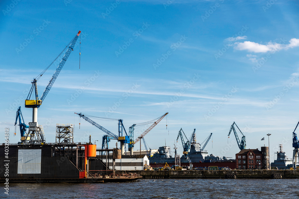 Container cranes and a battleship in Hamburg, Germany