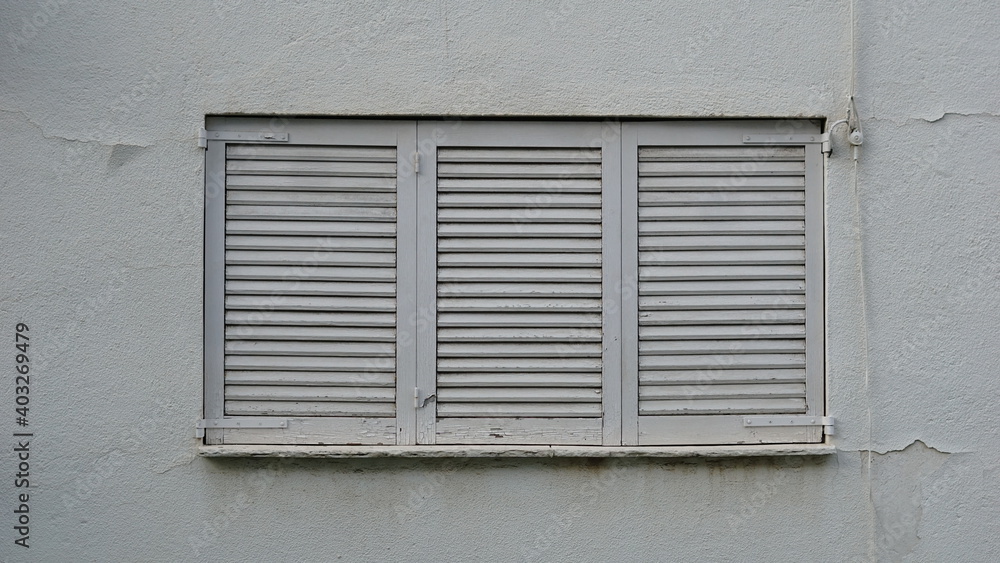 closed window with white wood shutters