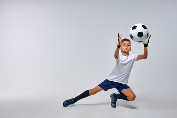 skilled goalkeeper boy get the ball in hands while defending football goal. isolated white background