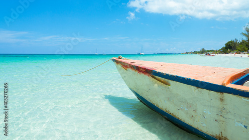 Fototapeta Naklejka Na Ścianę i Meble -  The crystalline waters of the beach of Negril, Jamaica. A rusty boat on the left.