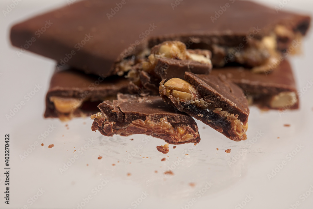 Broken bar of chocolate with nuts and caramel.