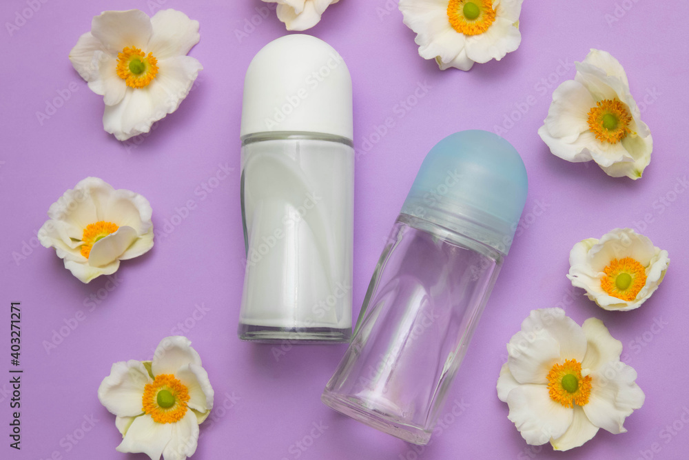 Two glass bottles of ball deodorants with white orchid flowers on a pink background close-up, personal care concept, advertising template and layout, product, perfume and body and skin care for women Two glass bottles of ball deodorants with white orchid flowers on a pink background close-up, personal care concept, advertising template and layout, product, perfume and body and skin care for women