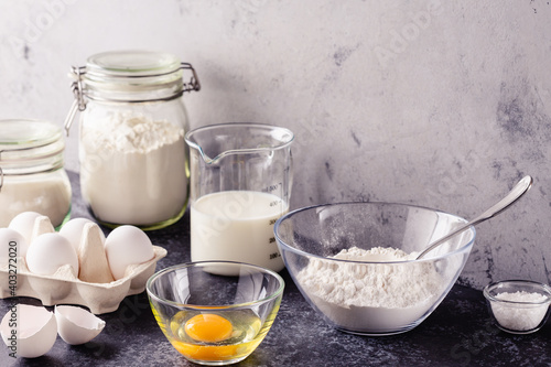 Cooking ingredients for dough, eggs, flour, sugar, milk.