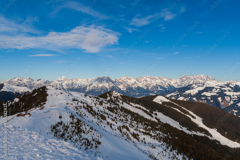 View of the snow-capped mountains in the Schmitten ski area in Zell am See. In the background is a beautiful sky with clouds.