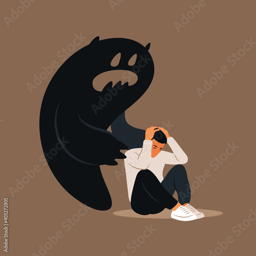 Fear or panic attack. Sad man with lowered head frightened with his own shadow. Depressed, solitude, anxiety concept.