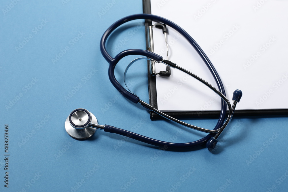 Stethoscope and tablet for recording patients on blue background Stethoscope and tablet for recording patients on blue background