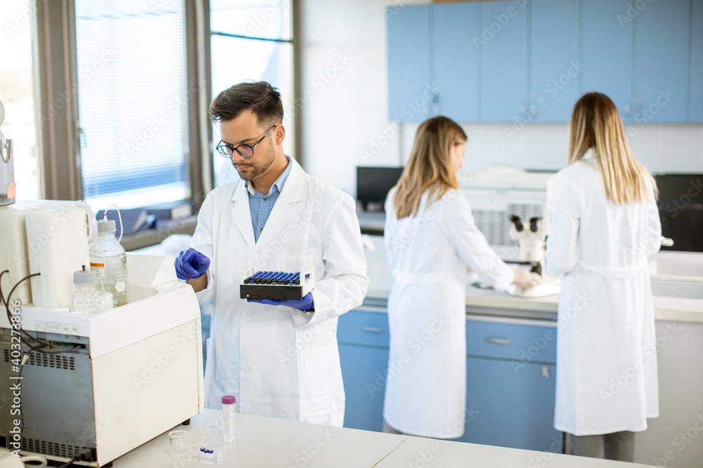 Obraz premium Researcher in protective workwear standing in the laboratory and analyzing liquid samples