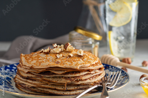 buckwheat pancakes with honey and hazelnuts on an old plate