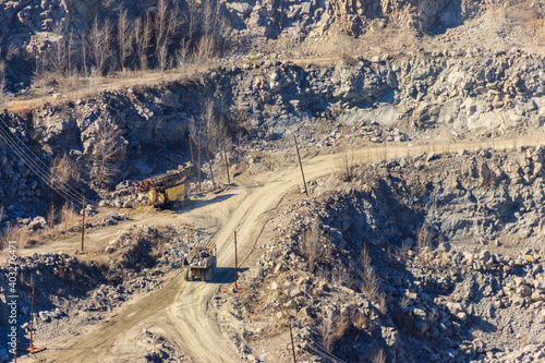 Huge granite quarry with working dump trucks and excavators
