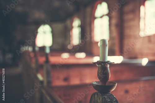 Medieval Baltic church interior with sun rays from the window falling on the candles. photo