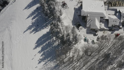 Ski Track at Kope winter resort Slovenia with skiers going downhill, Aerial top view flyover shot