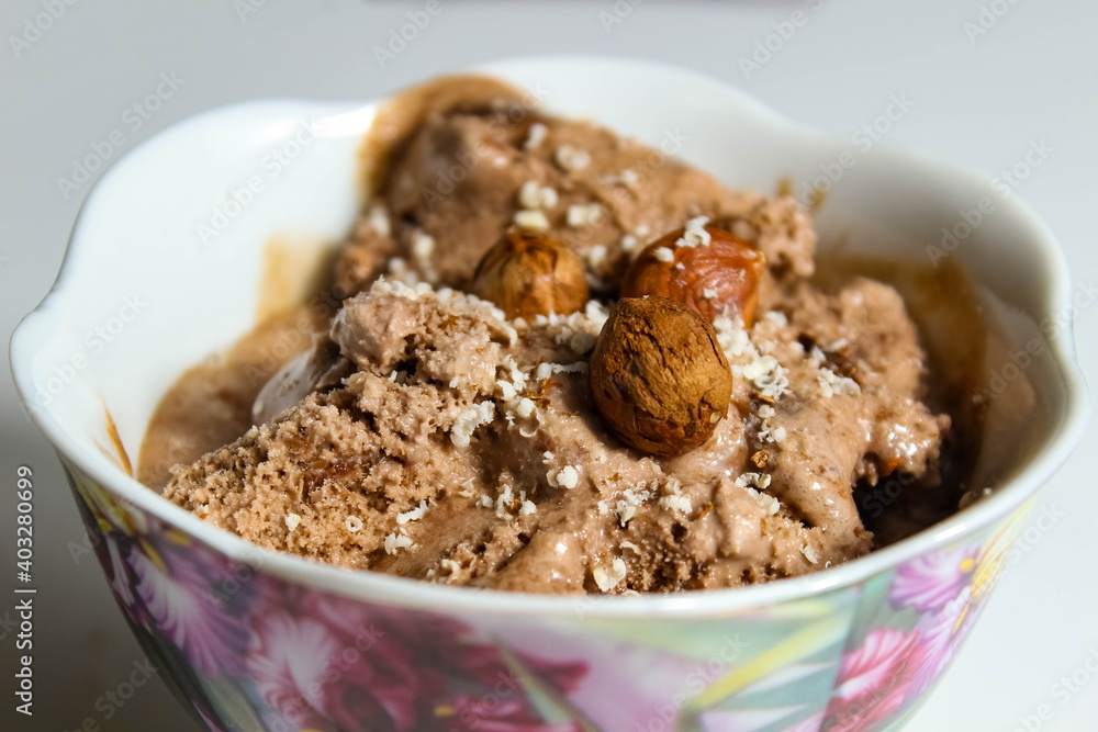 Chocolate ice cream with hazelnuts close-up, which is sprinkled with nut crumbs. Chocolate ice cream with hazelnuts close-up, which is sprinkled with nut crumbs.