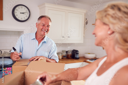 Schilderij op canvas Senior Couple Downsizing In Retirement Packing And Labelling Boxes Ready For Mov
