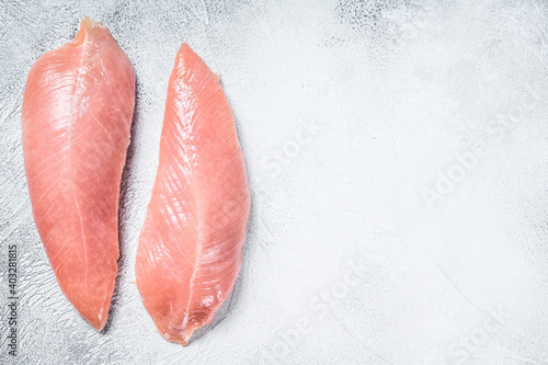 Raw Turkey steaks. Breast fillet. White background. Top view. Copy space