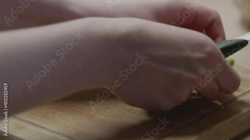 Des haricots verts coupés par une femme dans une cuisine