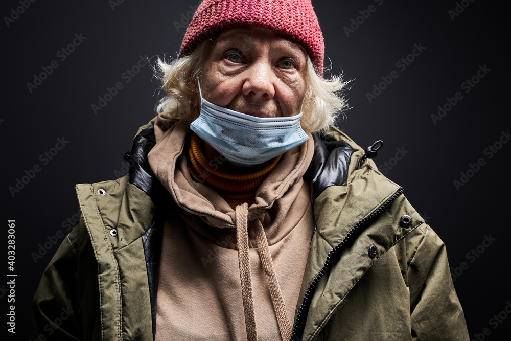 senior woman in dirty wear and medical mask isolated on black background, homeless female is suffering from hunger and cold, in desperation senior woman in dirty wear and medical mask isolated on black background, homeless female is suffering from hunger and cold, in desperation