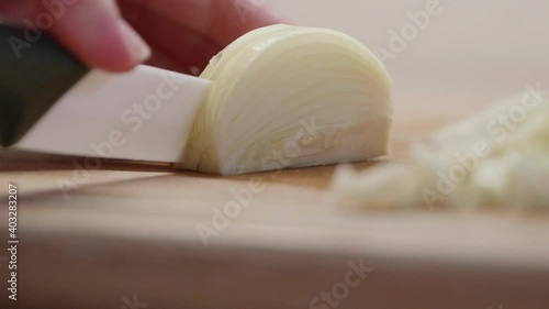 Une femme qui coupe un oignon sur un plan de travail