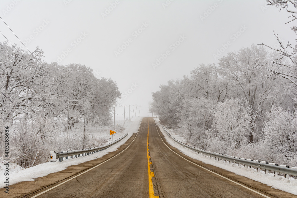 Fototapeta premium Illinois Rt 178 surrounded by snow and ice on a cold and foggy winters day.