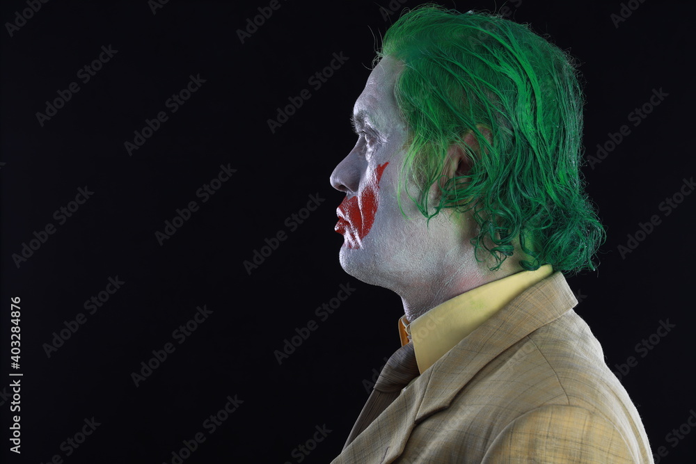 Portrait of a smiling man with clown makeup and green hair. Portrait of a smiling man with clown makeup and green hair.