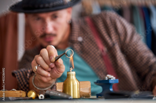 Fotografia close-up on fire, goldsmith is engaged in soldering jewelry rings, increase ring size