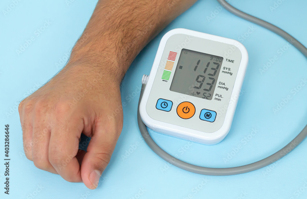 Man measures his blood pressure by electronic tonometer close-up Man measures his blood pressure by electronic tonometer close-up