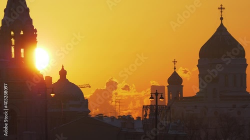 Telephoto shot of sun disk setting between the Sofievskaya Bell Tower
