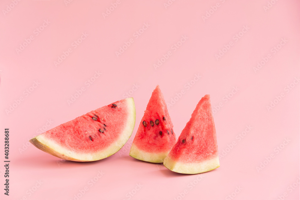 Three small pieces of watermelon on a pink background Three small pieces of watermelon on a pink background