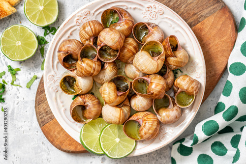 Escargots de Bourgogne. Snails with butter, herbs, and garlic in a plate top view.