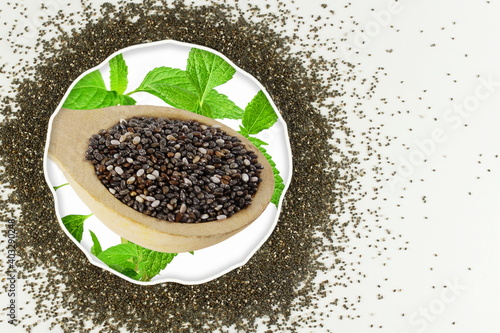 chia seeds Salvia hispanica isolated in spoon with plant leaves and copy space in frame