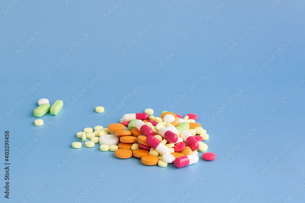 A slide of multi-colored pills on a blue background. A slide of multi-colored pills on a blue background.