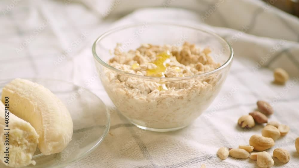 Overnight oatmeal bowl. Cooking healthy breakfast at home. Homey topping. Banana, plant milk and nuts ingredients. 4k video. Step by step recipe Overnight oatmeal bowl. Cooking healthy breakfast at home. Homey topping. Banana, plant milk and nuts ingredients. 4k video. Step by step recipe