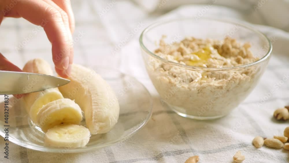 Overnight oatmeal bowl. Cooking healthy breakfast at home. Banana slice, honey, plant milk and nuts ingredients. 4k video. Step by step recipe Overnight oatmeal bowl. Cooking healthy breakfast at home. Banana slice, honey, plant milk and nuts ingredients. 4k video. Step by step recipe