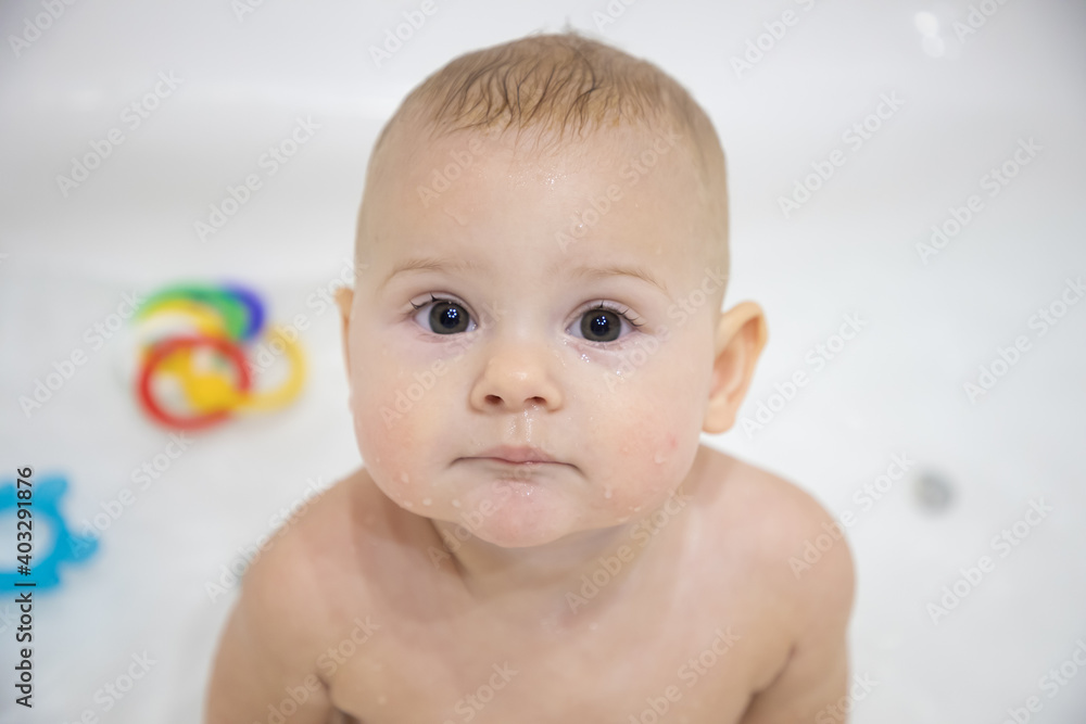 Cute baby girl bathing with toys and smiling in a big white bath Cute baby girl bathing with toys and smiling in a big white bath