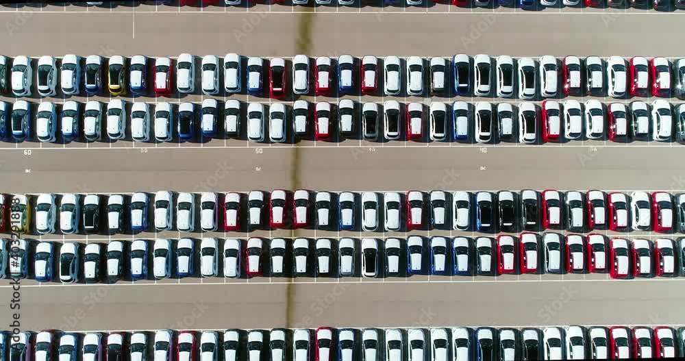 Parking during the day. There is a lot of cars parked in the parking lot - aerial view with a drone 4K Parking during the day. There is a lot of cars parked in the parking lot - aerial view with a drone 4K