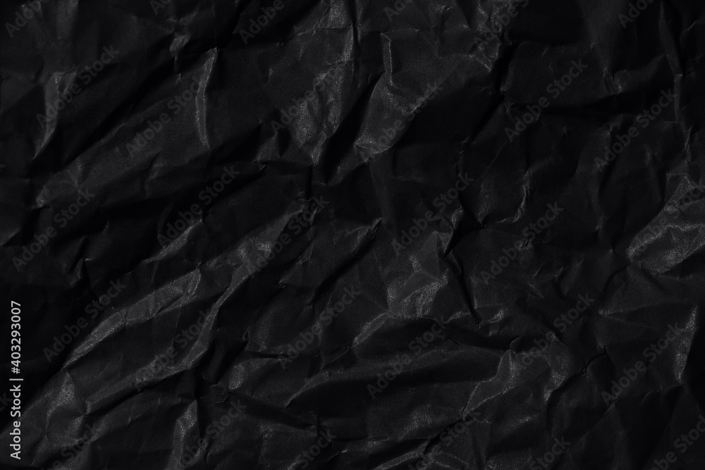 Black background. A crumpled sheet of black paper. Black background. A crumpled sheet of black paper.
