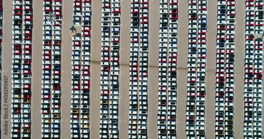 A large number of cars parked in a parking lot. Wonderful view with drone above white roofs of cars - aerial view 4K A large number of cars parked in a parking lot. Wonderful view with drone above white roofs of cars - aerial view 4K