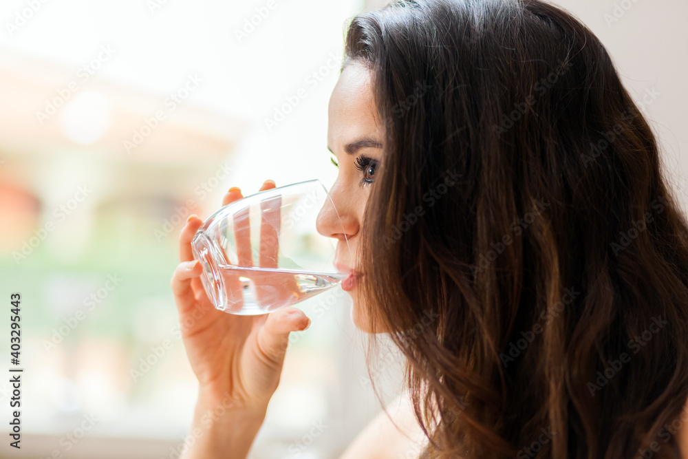 Beautiful young lady drinking water in restaurant Beautiful young lady drinking water in restaurant