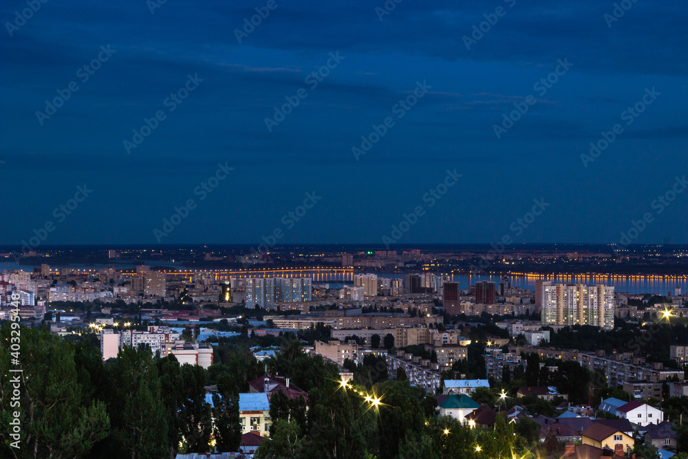 Fototapeta premium View of the city with high-rise buildings against the background of the river and sunset.
