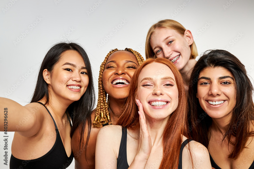 five smiling laughing beautiful women in bodysuit standing together, having fun and talking selfie looking at camera, isolated on white studio background five smiling laughing beautiful women in bodysuit standing together, having fun and talking selfie looking at camera, isolated on white studio background