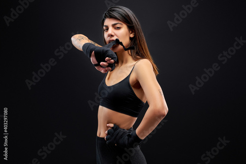 sportswoman wearing bandage on hands  going to fight  boxing and sport concept  isolated black background