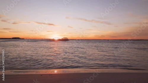 Time lapse shot from the sandy beach showing Avalon New Jersey in motion and epic colorful sunset and golden hour at horizon. Sea Isle City, United States America. photo