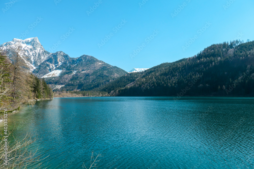 Leopoldsteiner lake in Austria. The lake is surrounded by high Alps. The shallow water is crystal clear, spring water has a calm surface. Early spring. Glacier in the back. Calmness and nostalgia