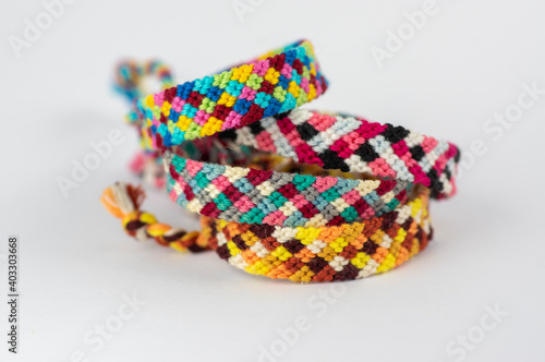Group of handmade homemade colorful natural woven bracelets of friendship isolated on white background
