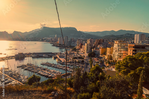 Beautiful sunset with views of the marina and the beach of the city of Calpe from the Peñon de Ifach natural park (Alicante, Spain). photo