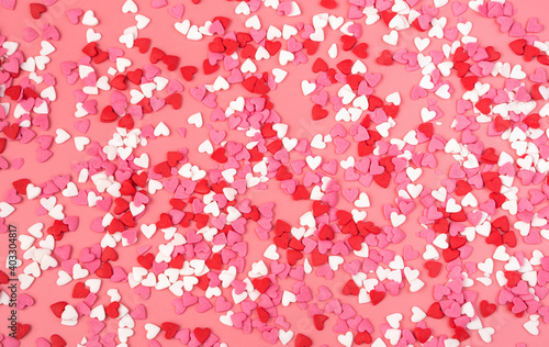 Romantic background with small hearts on pink background. The view from the top. Concept February 14.