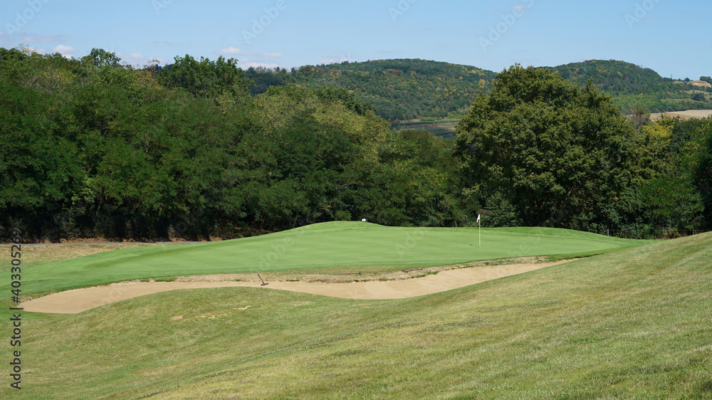 Large sandy bunker in front of green, golf concept