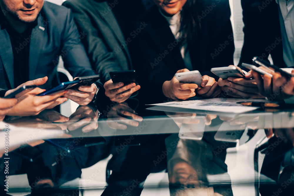 © yurolaitsalbert - close up . employees with smartphones sitting at the Desk © yurolaitsalbert - close up . employees with smartphones sitting at the Desk