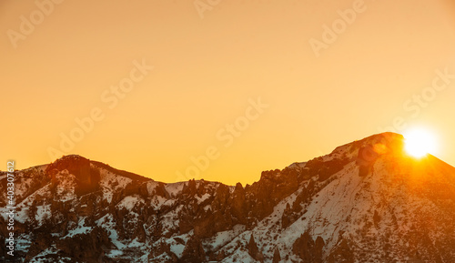 Beautiful panoramic sunrese over the mountains and  snow-covered hills. photo